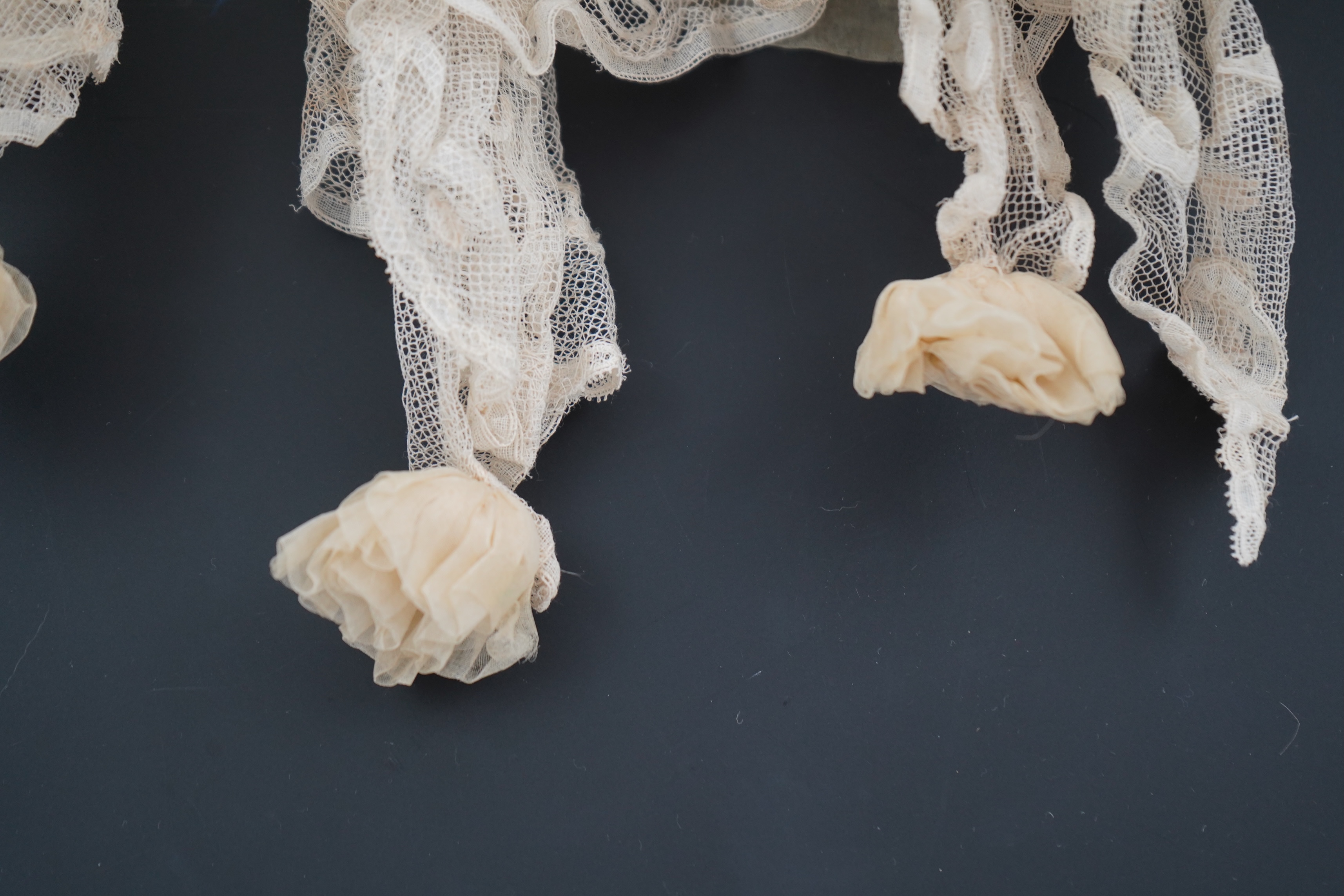 An Edwardian high collared cream tape lace wedding over blouse, made with a deep net frill and cream chiffon rose detail hanging from lower edge, top of collar to rose detail at the front 46cm. Condition - fine silk chif